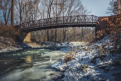 Bridge over river during winter