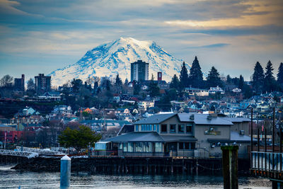 A view of buildings in tacoma, washington with mount rainier behind.