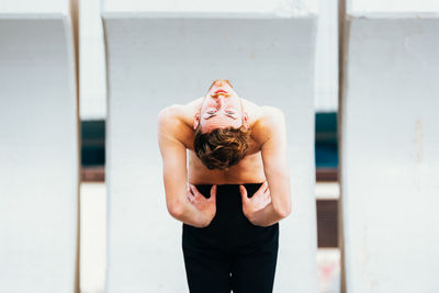 Rear view of woman standing against wall