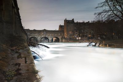 Poulteney bridge in front of river at dusk