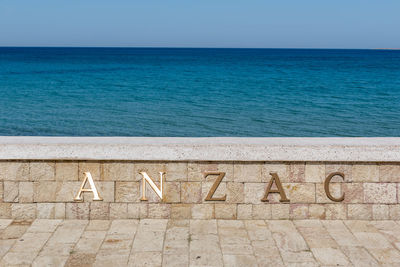 Text on beach against clear sky