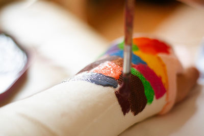 Cropped hand of person with colorful bandage