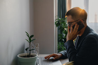 Young woman using mobile phone at home