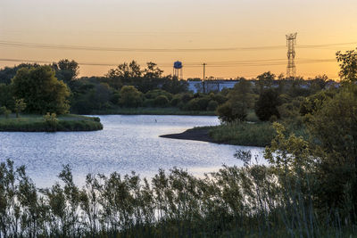 Scenic view of river against clear sky at sunset
