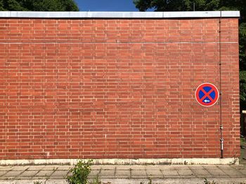 Road sign against brick wall