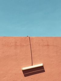 Tilt image of wall against clear blue sky