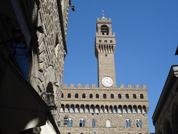 Low angle view of clock tower against blue sky