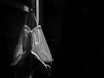 Close-up of clothes hanging on window at night