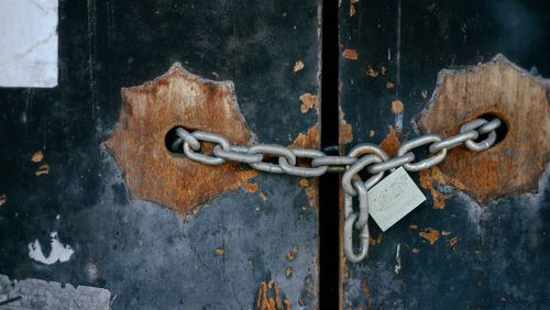 Padlock and chain on closed wooded door