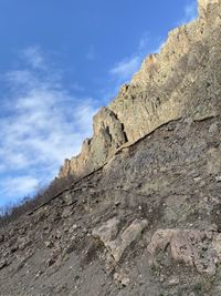 Low angle view of rocky mountain against sky