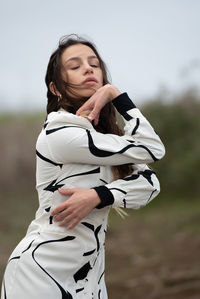 Portrait of young woman standing on field