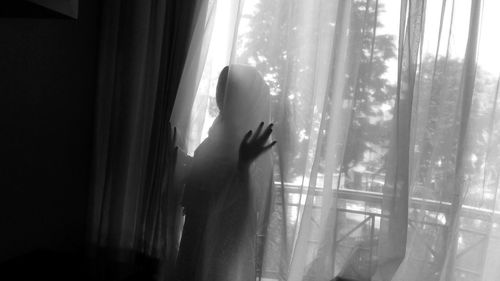 Woman looking through window