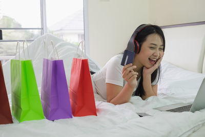 Young woman using mobile phone on bed