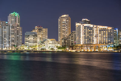 Illuminated buildings in city against sky at night