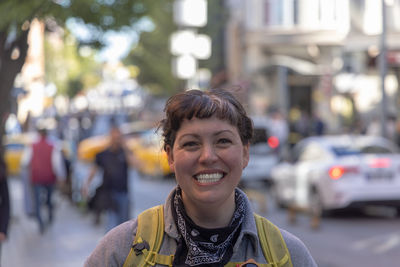 Portrait of young woman standing in city