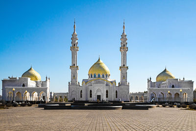 View of buildings against clear blue sky