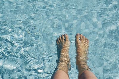 Low section of person legs in swimming pool