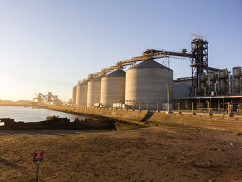 Trucks are unloading their cargo at quequen port at the sunset