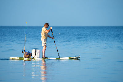 Man surfing in sea against sky