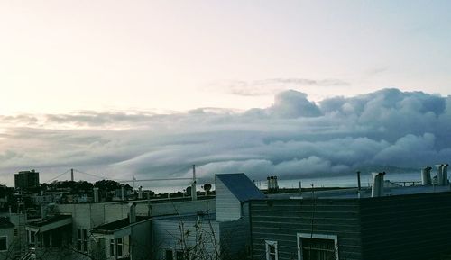 View of cityscape against cloudy sky