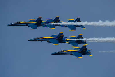 Low angle view of airplane flying against blue sky