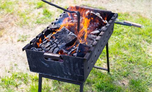 Brazier or grill with burning charcoal close-up. the man is stirring the coals with a hot poker. 