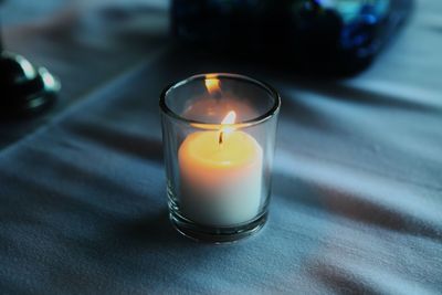 Close-up of illuminated candle on table