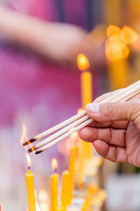 Close-up of hand lighting incenses