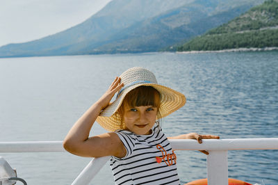 Portrait of boy in sea against mountain