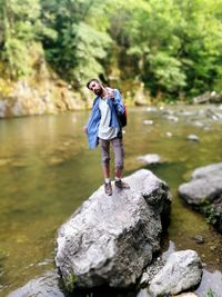 Full length of man standing on rock against trees