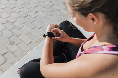 Sportswoman checking time on smart watch during sunny day