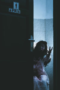 Spooky woman gesturing in bathroom