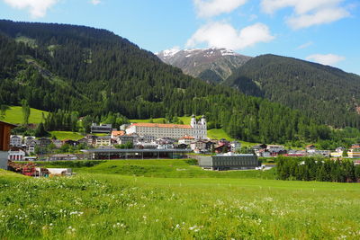 Houses on field by mountains against sky