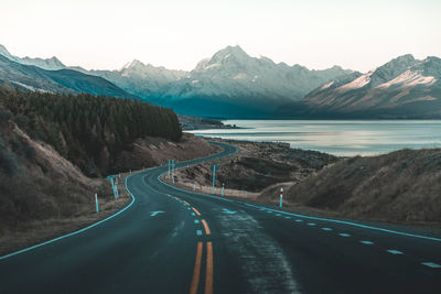 Road by mountains against sky