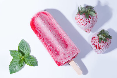 Close-up of strawberry popsicle against white background