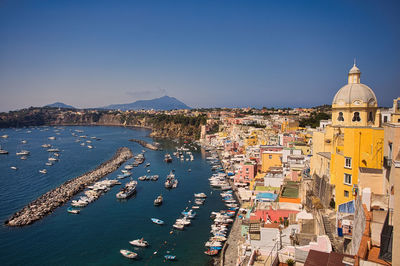 High angle view of townscape by sea against clear sky in procida island