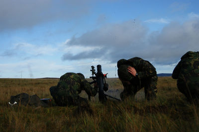 Man photographing on field against sky