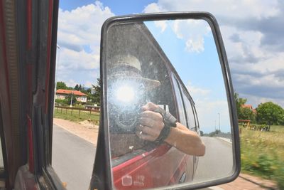 Reflection of trees in side-view mirror