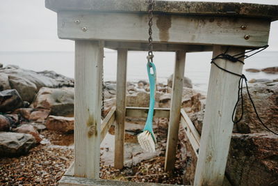 Close-up of brush hanging on wooden table at beach