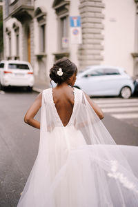 Rear view of bride standing on road