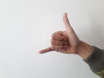 Close-up of human hand against white wall