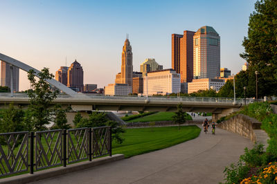 Bridge and buildings in city against clear sky