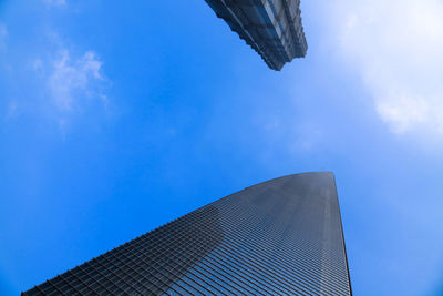 Low angle view of modern building against blue sky