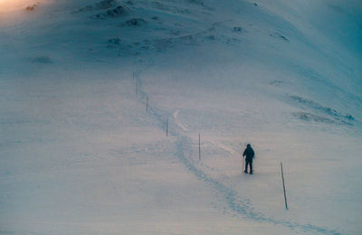 High angle view of person hiking on snow covered field