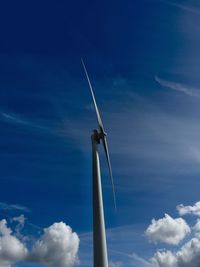 Low angle view of windmill against blue sky