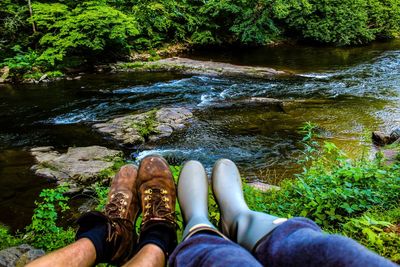 Low section of friends against stream in forest