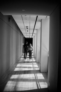 Rear view of men walking in corridor