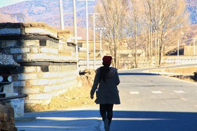 Rear view of man walking on street in winter