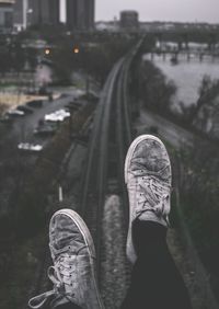 Low section of person sitting above railway tracks