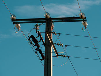 Low angle view of electricity pylon against sky